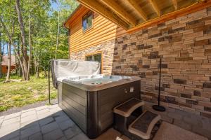 a hot tub sitting on a patio next to a brick wall at Aspen Summit by Railey Vacations in McHenry
