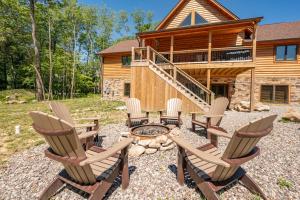 a group of chairs and a fire pit in front of a log cabin at Aspen Summit by Railey Vacations in McHenry