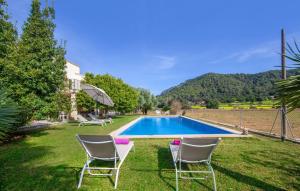 a yard with chairs and a swimming pool at Sa Mina De Crestatx in Sa Pobla