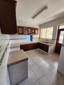 a kitchen with wooden cabinets and a sink in it at MoDi's Seaside Nest in Mombasa