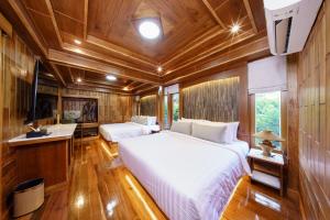 a bedroom with two beds in a room with wooden walls at Calisto Valley I Luxury Pool Villa Krabi in Ao Nam Mao