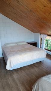 a bedroom with a large bed with a wooden ceiling at Mindo Suites - Rufous in Mindo