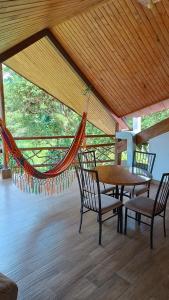 a porch with a hammock and a table and chairs at Mindo Suites - Rufous in Mindo