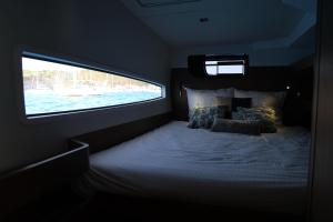 ein Bett in einem Zimmer mit Fenster in der Unterkunft Let's go catamaran in Saint Barthelemy