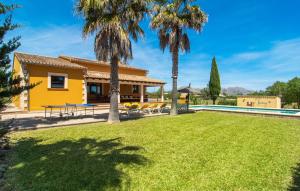 a yellow house with a pool and palm trees at Can Jaume Pollenca in Pollença