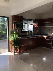 a kitchen with wooden cabinets and a sink and a plant at Casa- alojamiento Gerez in San Antonio de Arredondo