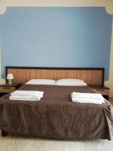 a bedroom with a large bed with two towels on it at Villamelchiorre 1 in Milan