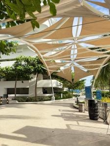 a large tan umbrella in front of a building at Azure North - Aurora Sky in San Fernando