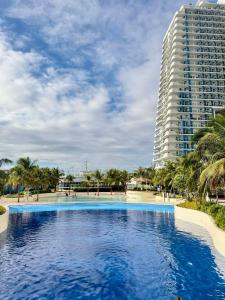 a large swimming pool in front of a tall building at Azure North - Aurora Sky in San Fernando