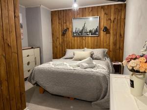 a bedroom with a bed with a wooden wall at Departamento outlet Puerto Montt con estacionamiento in Puerto Montt