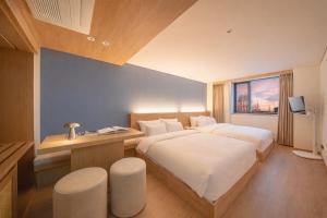 a bedroom with two beds and a desk and a window at 하로스테이 신사점 in Seoul
