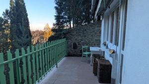 a balcony of a house with a table and a window at Gesztenyés Backpackers in Kőszeg