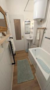 a white bathroom with a tub and a sink at Gesztenyés Backpackers in Kőszeg