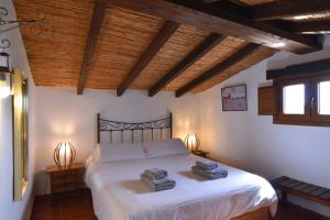 a bedroom with a bed with two towels on it at Finca La Sierra with private Pool in Cómpeta +57 photos