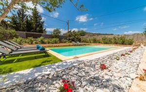 a swimming pool in a garden with a bench next to a yard at Son Cullera Petit in Son Servera
