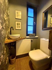 a bathroom with a white toilet and a sink at Honey Gardens venkovský apartmán v přírodní zahradě in Oleška