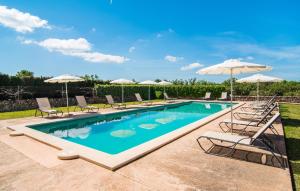 a swimming pool with chairs and umbrellas at Son Capellot Cinco in Felanitx