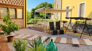 a patio with a table and chairs and an umbrella at Bed & Breakfast Carpe Diem in Solferino