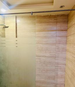 a sliding shower door in a room with wood at Modern City Escape Bahria hieghts in Rawalpindi