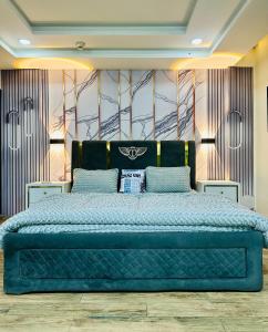 a bedroom with a large blue bed in a room at Modern City Escape Bahria hieghts in Rawalpindi