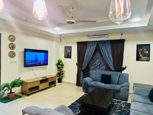a living room with a couch and a tv at Modern City Escape Bahria hieghts in Rawalpindi