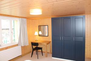 a room with a desk and a blue closet at Apartment Büel in Krattigen in Krattigen
