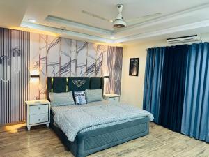 a bedroom with a bed and blue curtains at Modern City Escape Bahria hieghts in Rawalpindi +6 photos