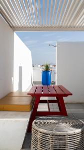 a red picnic table on a balcony with a potted plant at Buendía Corralejo Nohotel in Corralejo