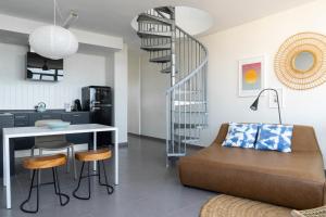 a kitchen and a living room with a spiral staircase at Buendía Corralejo Nohotel in Corralejo +149 photos