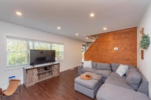 a living room with a couch and a flat screen tv at Ballers Bungalow by Railey Vacations in Swanton +35 photos
