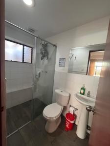 a bathroom with a toilet and a sink and a shower at Hostal Amanari in Popayan +46 photos