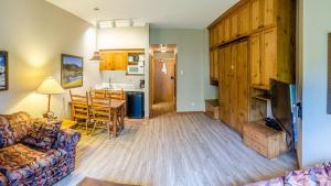 a living room with a couch and a table and a kitchen at Cahilty #103 in Sun Peaks