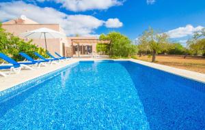 a swimming pool with chairs and a house at Ses Comunes in Campos