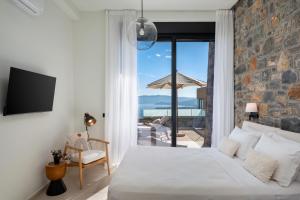 a bedroom with a bed and a view of the ocean at Majestic View Villas in Agios Nikolaos +54 photos