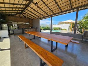 a large wooden table in a room with a view at Espaço premium, Casa com 5 quartos, piscina aquecida & Jacuzzi in Caldas Novas