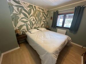 a bedroom with a bed with a leafy wallpaper at Le Nid de Chartreuse in Saint-Christophe