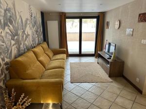 a living room with a couch and a television at Le Nid de Chartreuse in Saint-Christophe
