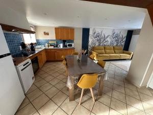 a kitchen and living room with a table and chairs at Le Nid de Chartreuse in Saint-Christophe