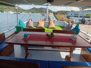 a table on the back of a boat with pillows at Sharing trip komodo 3d 2n in Labuan Bajo +2 photos