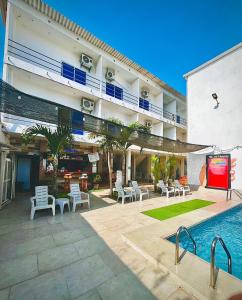 a hotel with a pool and a tv in a courtyard at Casa de Huéspedes Playas Arena in Playas