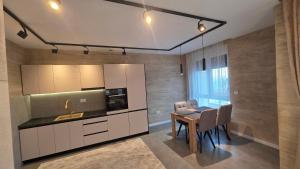 a kitchen and dining room with a table and chairs at Apartman Nadja in Šabac