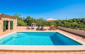 a swimming pool on top of a deck with an umbrella at Can Baldo in Sencelles