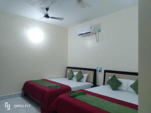 two beds sitting next to each other in a room at Hotel Sunshine in Konārka