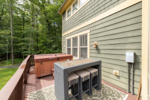 a deck with a table and a grill on a house at Bear Foot by Railey Vacations in Oakland