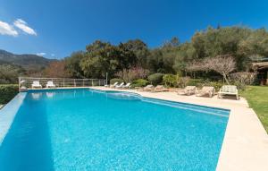 a swimming pool with chaise lounge chairs in a yard at Sa Tafona in Esporles