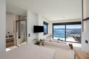 a living room with a couch and a large window at Majestic View Villas in Agios Nikolaos
