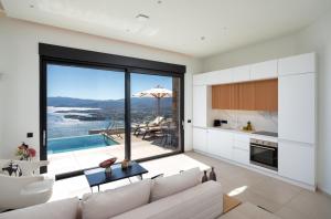 a living room with a couch and a kitchen with a view at Majestic View Villas in Agios Nikolaos
