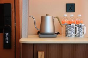 a coffee maker on a counter with bottles of water at A Hotel Farrer Park - Newly Renovated in Singapore +48 photos