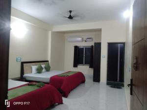a hotel room with two beds with red sheets at Hotel Sunshine in Konārka