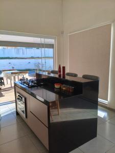a kitchen with a stove and a view of the ocean at Casa Condomínio Ninho Verde II in Pardinho